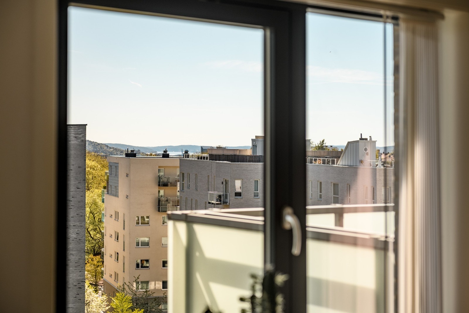 Fra stuen kan du nyte en vidstrakt og fri utsikt som virkelig understreker leilighetens høye plassering i bygget. Galleribilde