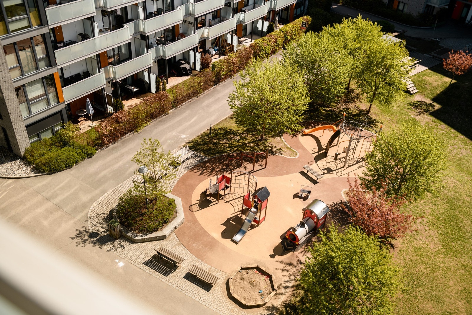 Balkongen vender ned mot grønne og velstelte fellesarealer, som gir en hyggelig og åpen ramme rundt uteplassen. Galleribilde