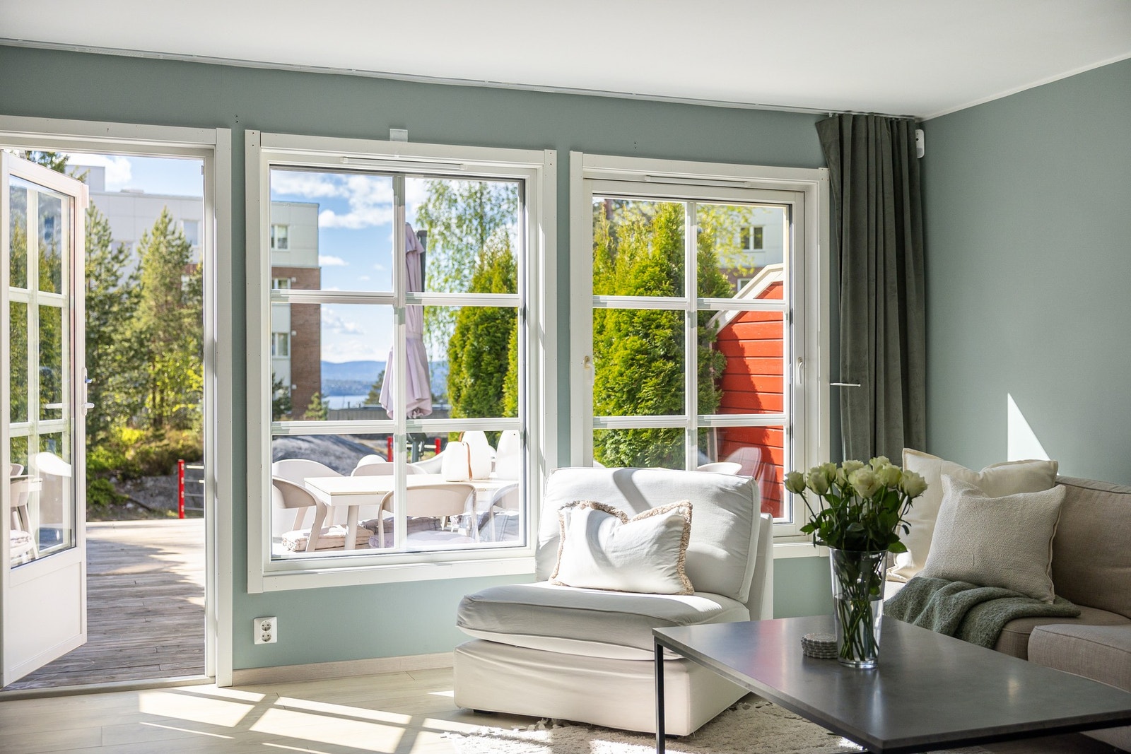 Lys og innbydende stue med store vindusflater som slipper inn rikelig med naturlig lys og skaper en åpen og luftig romfølelse. Galleribilde