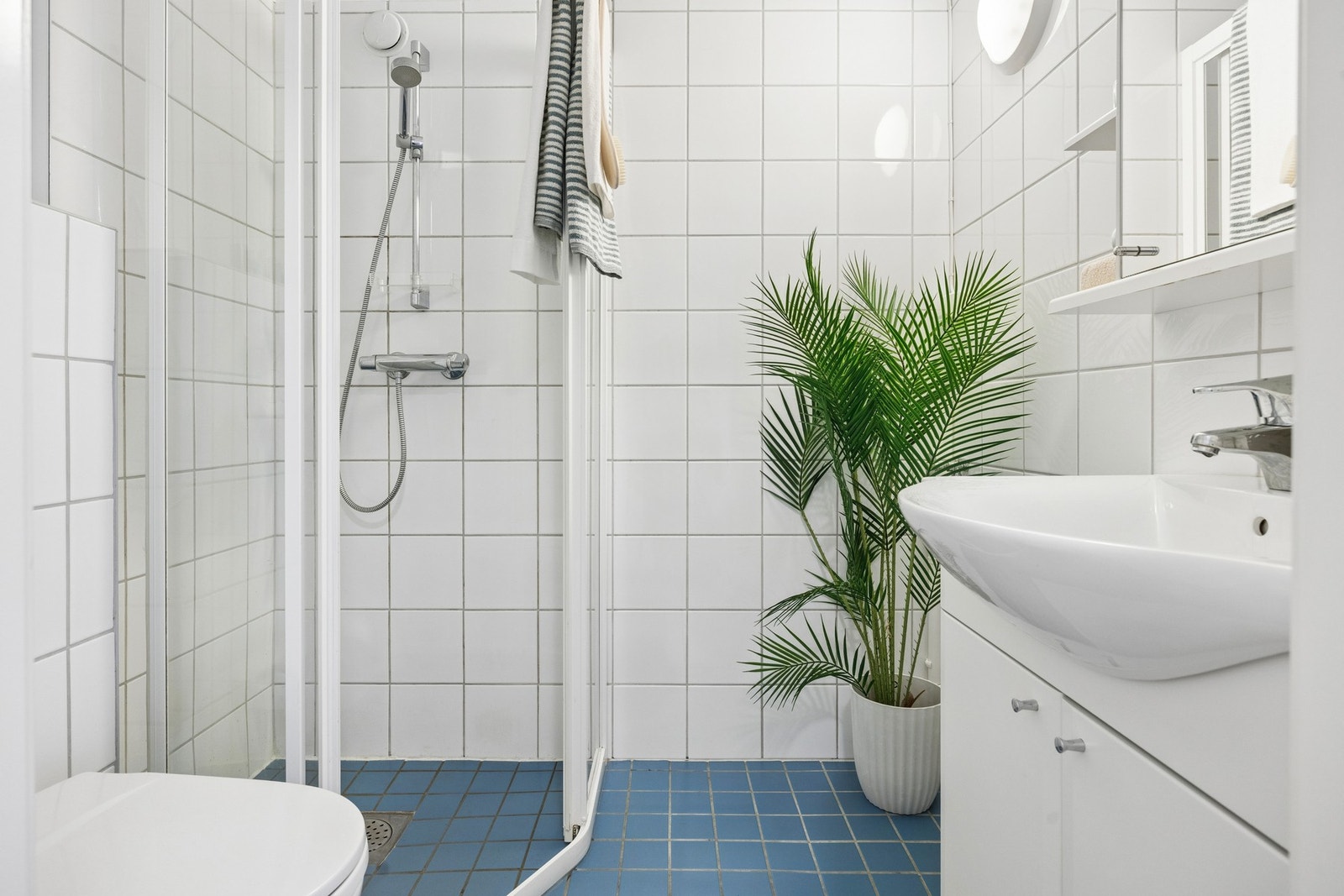Flislagt bad med dusjhjørne og opplegg for vaskemaskin. Det er også lagt opp til felles vaskeri på loft. Galleribilde