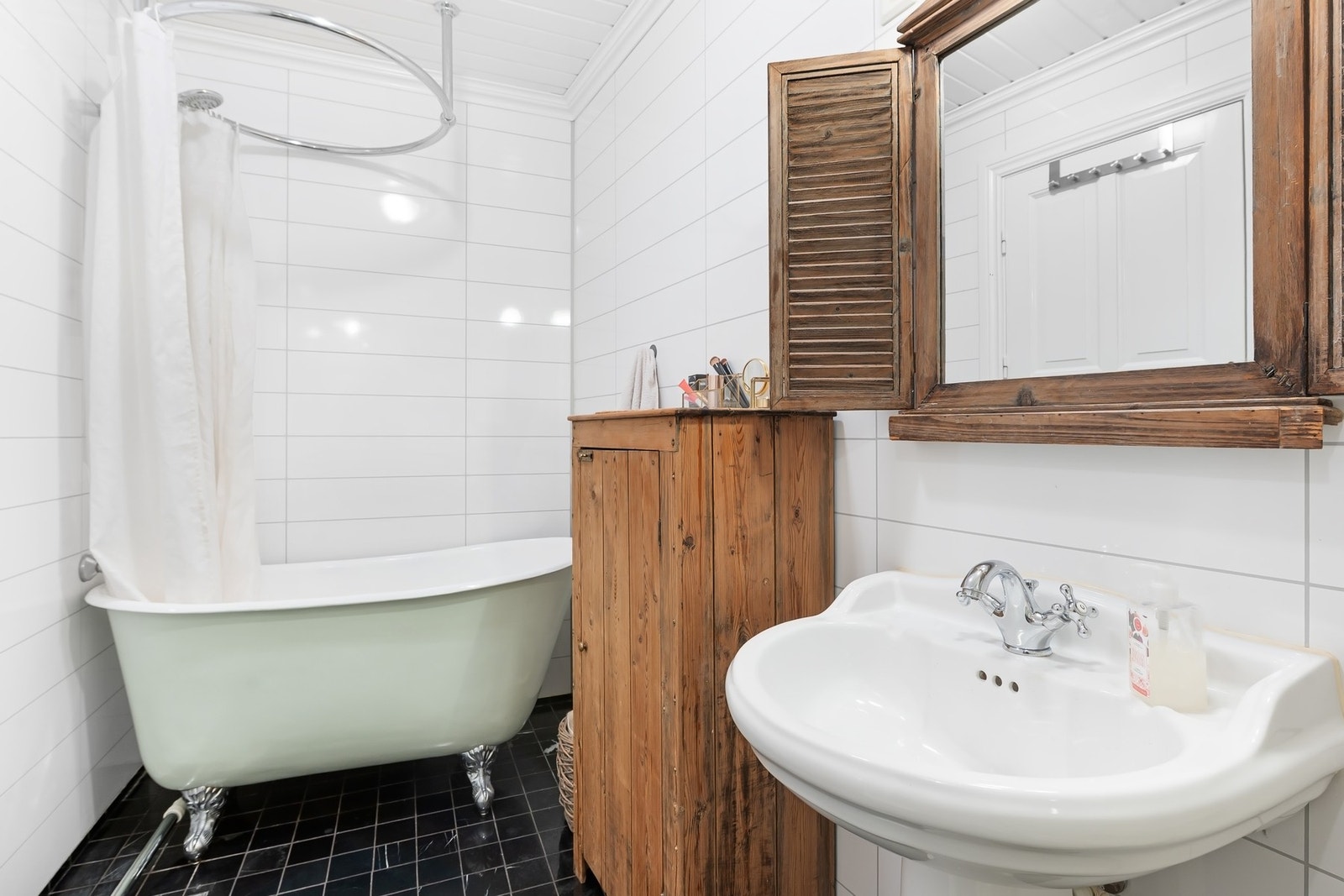 Badet har servant i porselen, badekar med dusj og toalett. Galleribilde