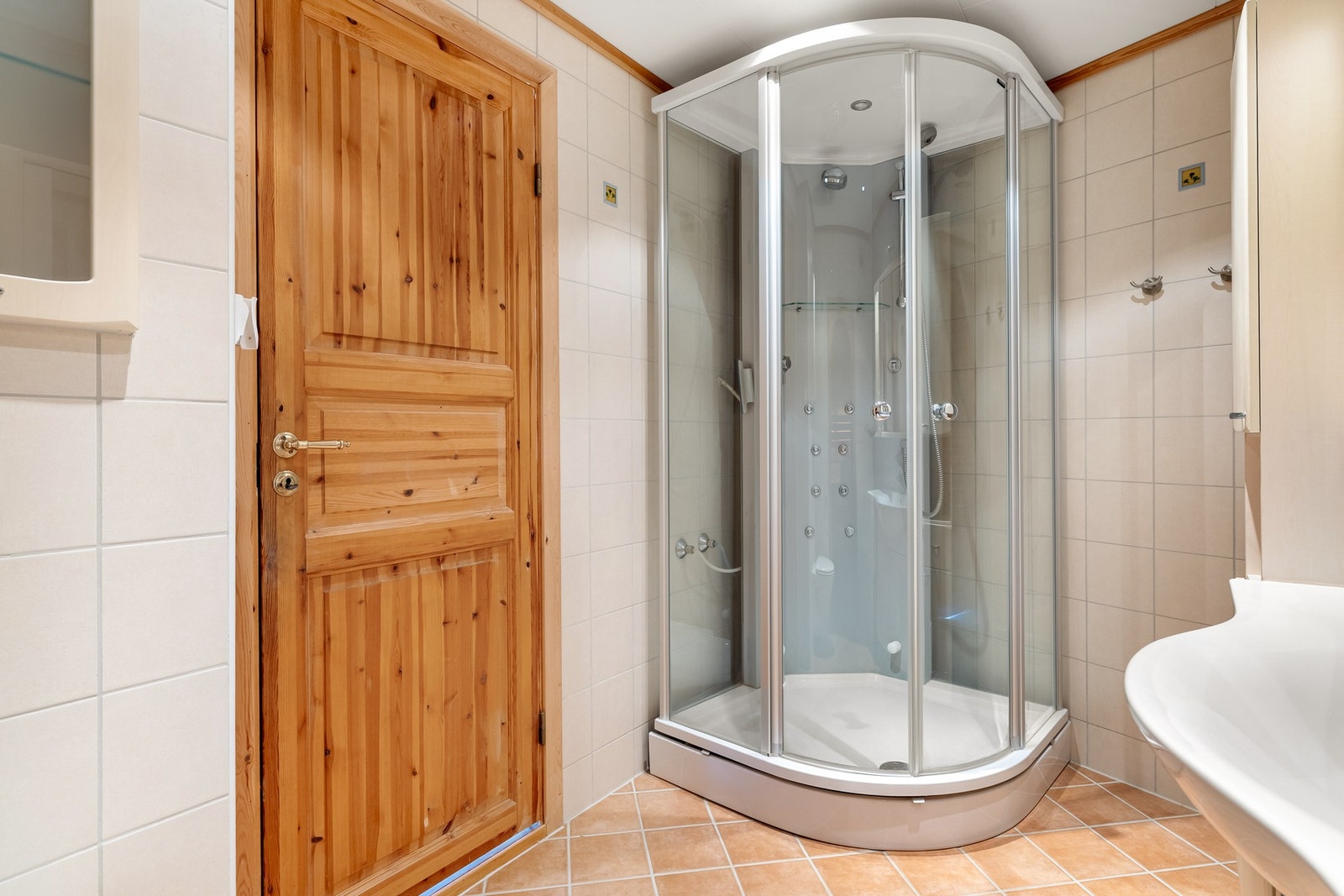 Badet er innredet med vegghengt toalett, dusjkabinett med steamdusj og baderomsmøblement med speil og belysning. Galleribilde