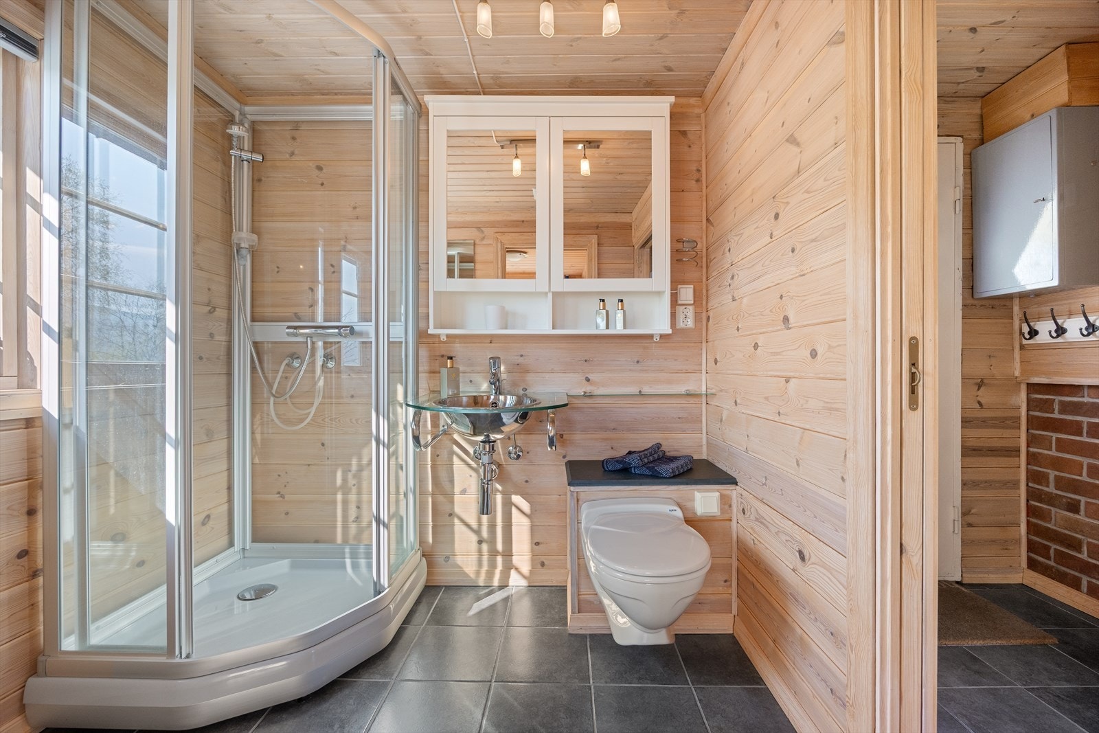 Badet er fra 2005 og har flislagt gulv med varmekabler, dusjkabinett, vakuumtoalett og mekanisk ventilasjon. Galleribilde
