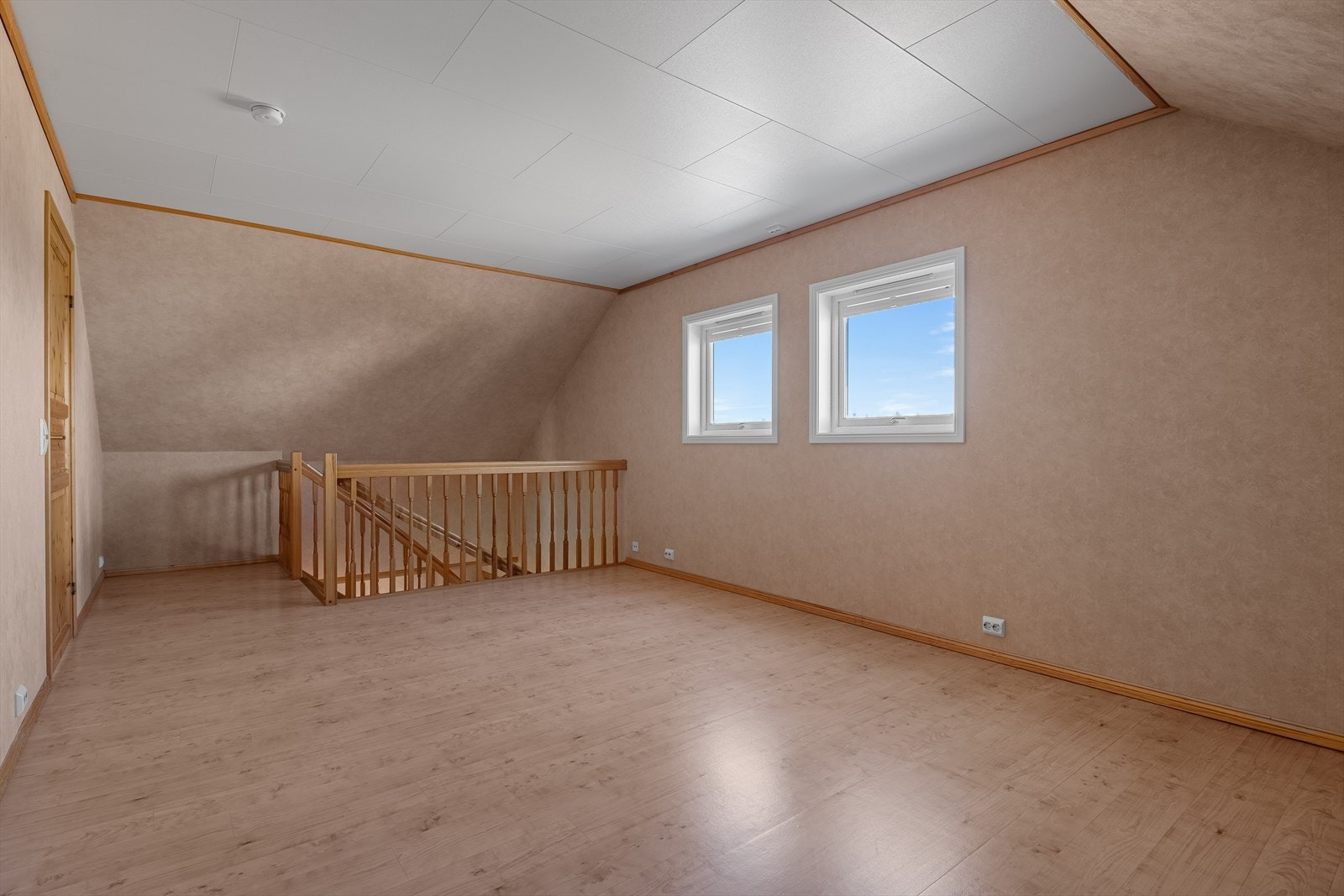 Loftstuen i andre etasje gir ekstra spillerom og fungerer som et sosialt samlingspunkt for etasje - fra vinduene er det flott utsikt, en kan til og med skimte havet i det fjerne. Galleribilde