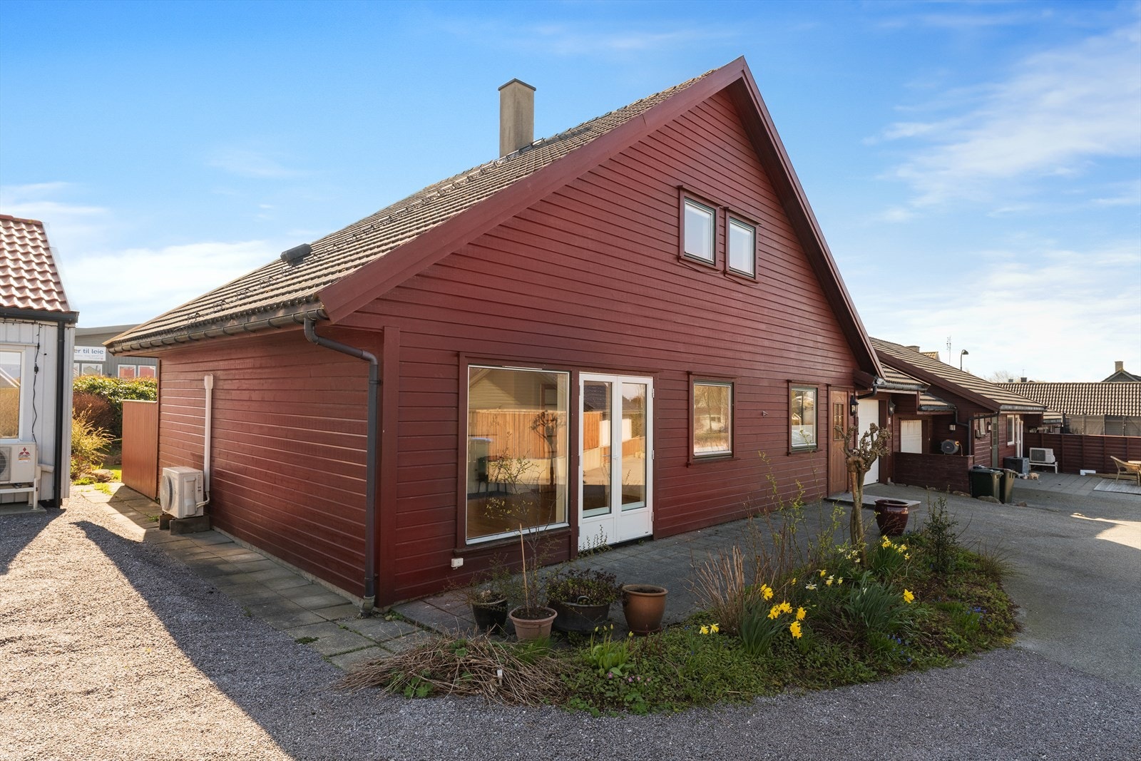 Asfaltert gårdsrom med parkering foran den integrerte garasjen. Galleribilde