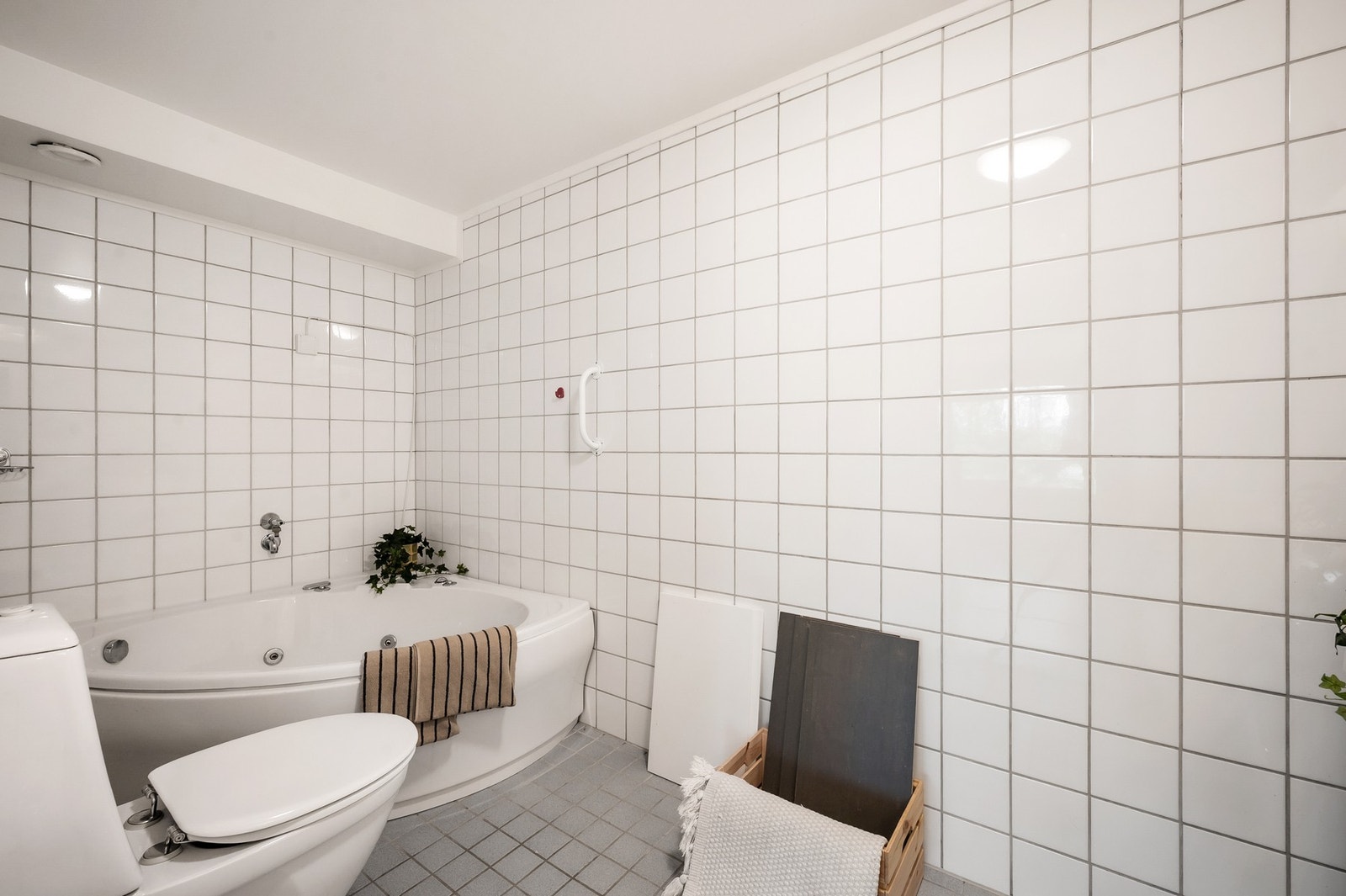 Badet er innredet med servant i innredning, toalett, badekar og opplegg for vaskemaskin Galleribilde
