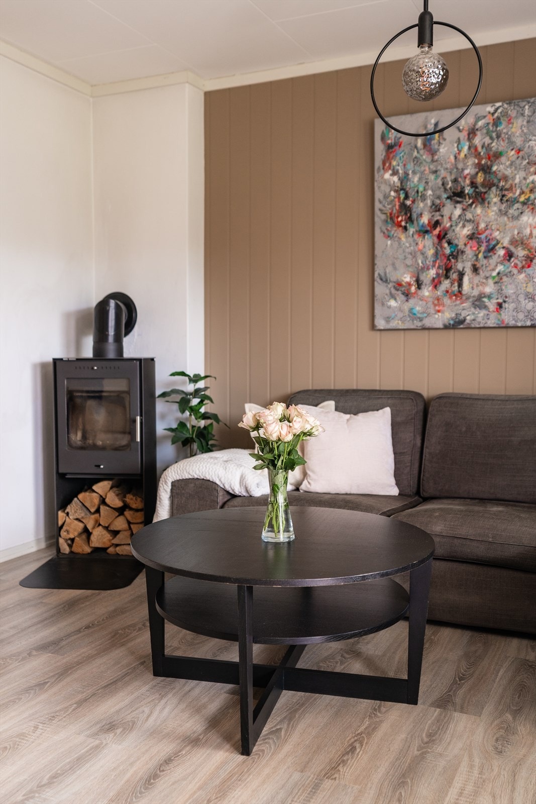 En flott peisovn er sentralt plassert i stuen. Den gir ikke bare behagelig varme på kjølige dager, men tilfører også en lun og hyggelig atmosfære som løfter helhetsinntrykket av leiligheten. Galleribilde