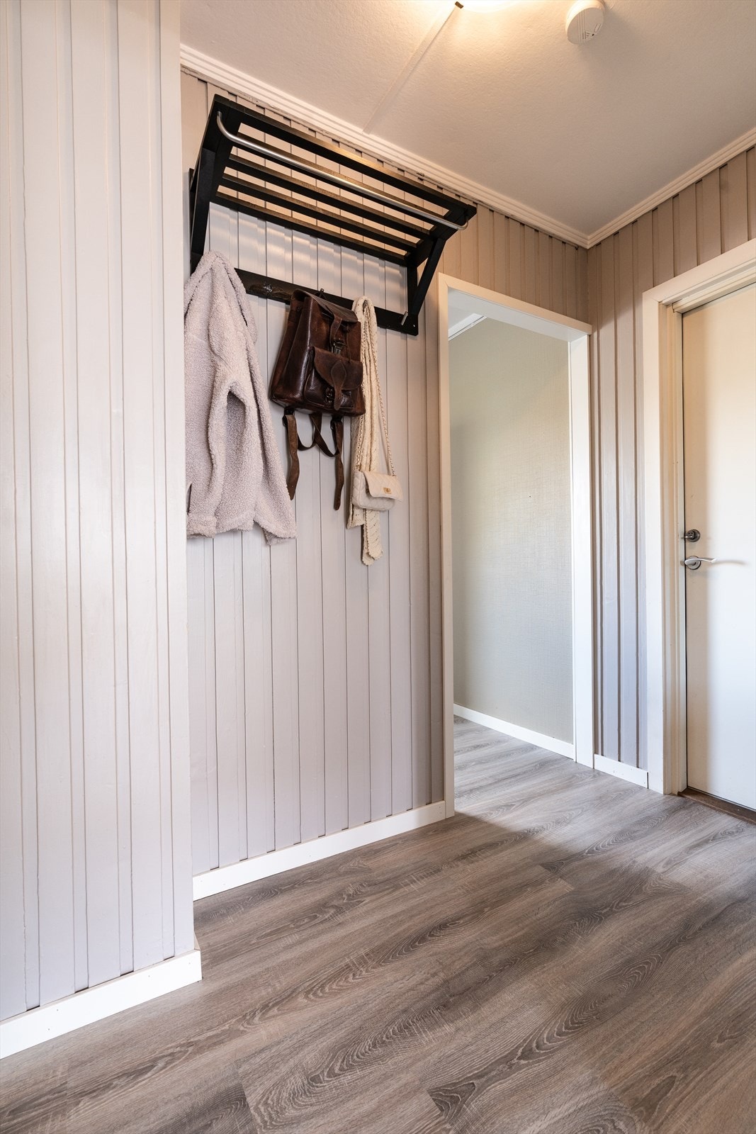 Her oppleves rommet som ryddig og innbydende, med muligheter for oppbevaring av yttertøy og sko. Galleribilde