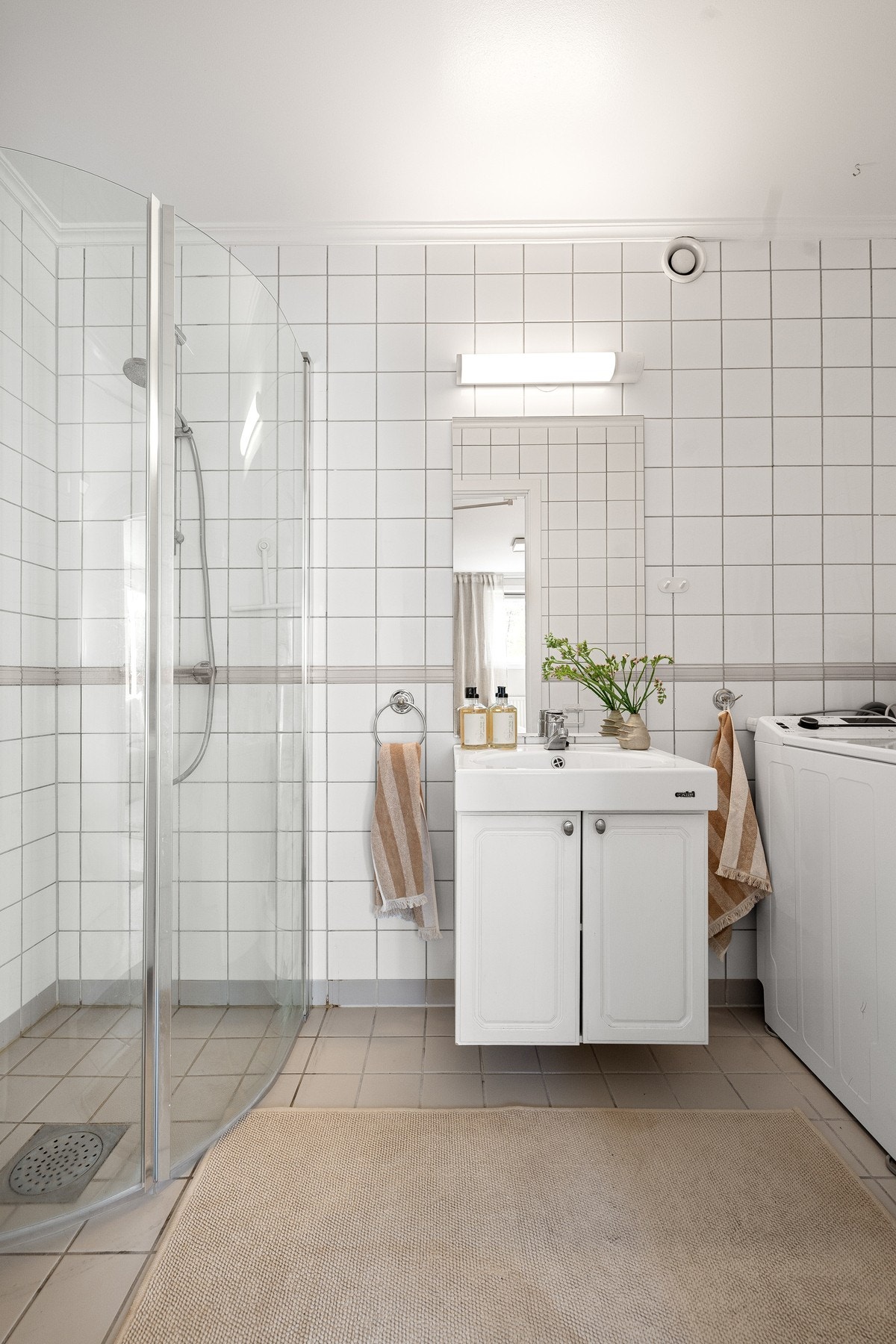 Flislagt bad med gulvvarme og opplegg for vaskemaskin. Galleribilde