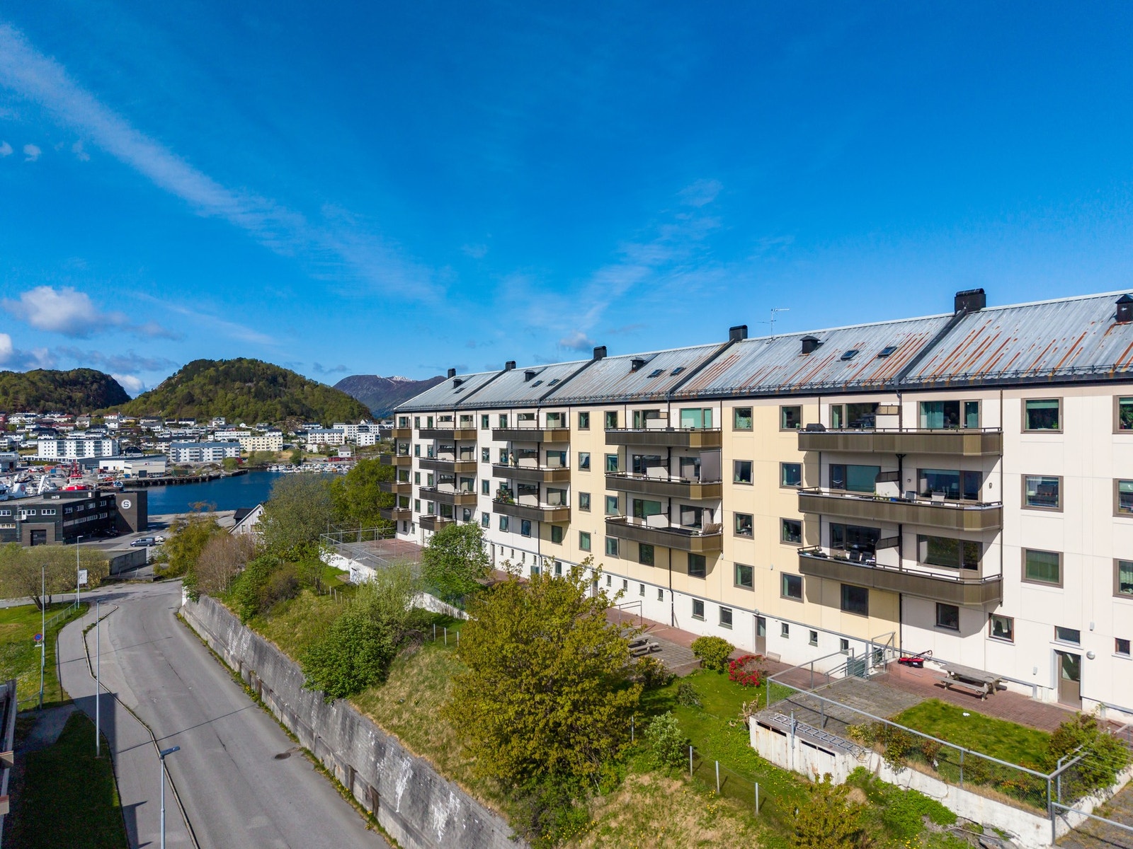 Fasade sett fra syd. Borettslaget disponerer et flott uteområde opparbeidet med plen, blomster og sitteplasser. Galleribilde