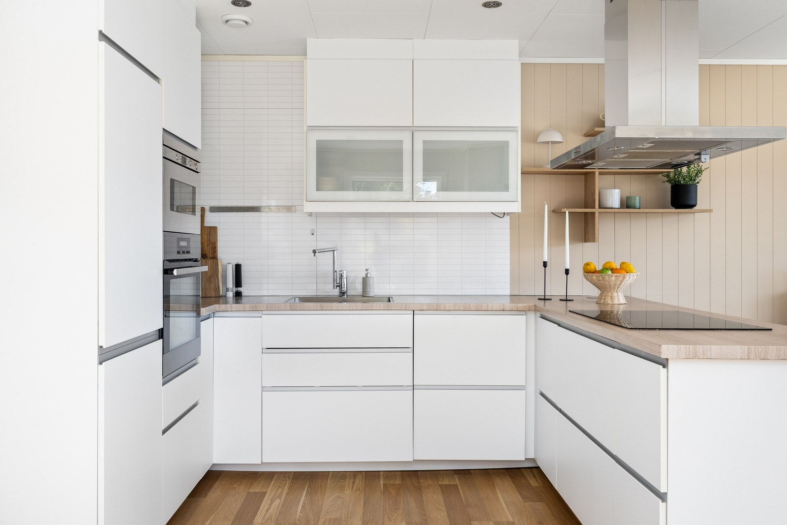 Ikea-innredning med glatte fronter og mørk laminat benkeplate, som senere er foliert med treimitasjon. Galleribilde