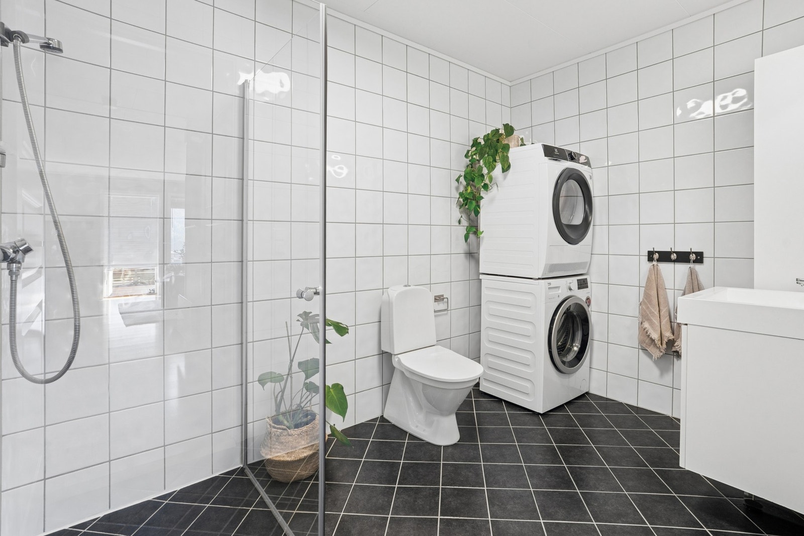 - Badet er innredet med dusjhjørne, toalett, servant med møblement og opplegg for vask/tørk - Galleribilde