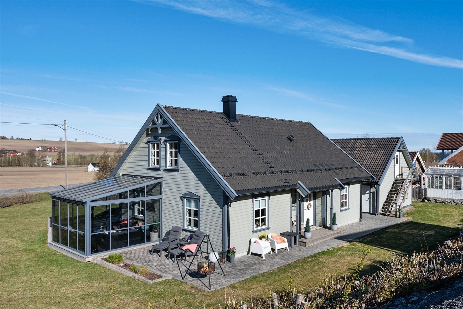 Eiendommen er pent opparbeidet med gressplen, beplantning og belegningsstein. Galleribilde