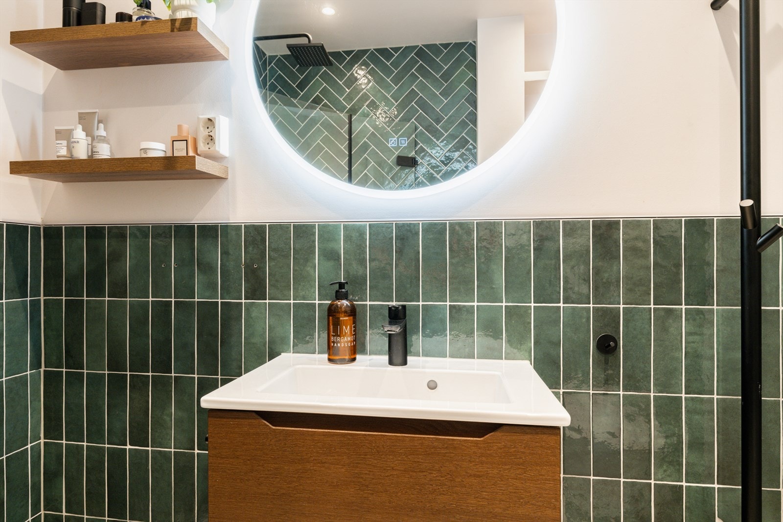 Badet er utstyrt med servant, veggmontert klosett og dusjsone med dusjing direkte på flis. Galleribilde