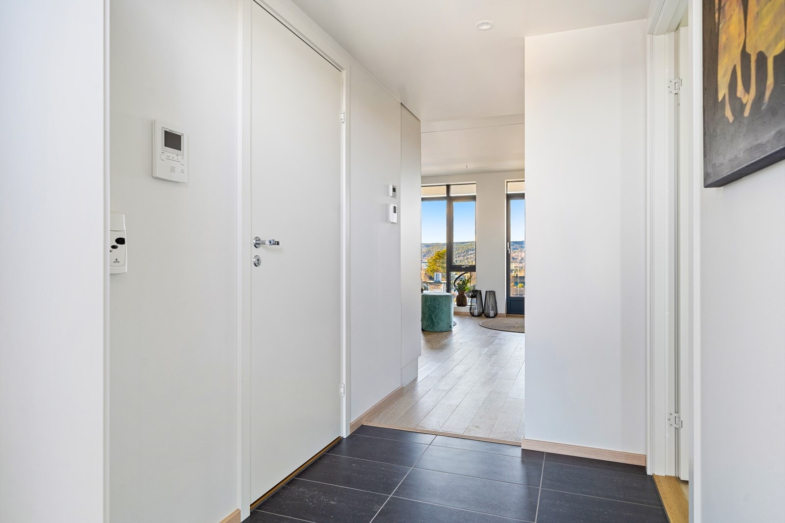 Entréen er flislagt med gulvvarme og gir et godt førsteinntrykk med oversikt helt mot de store vindusflatene i stuen. Galleribilde