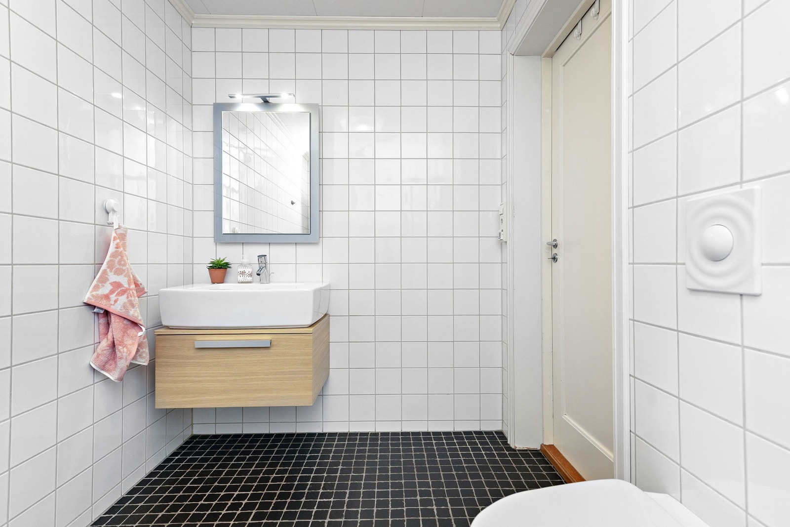 Badet er utstyrt med servantskap, vegghengt toalett og dusjsone. Galleribilde