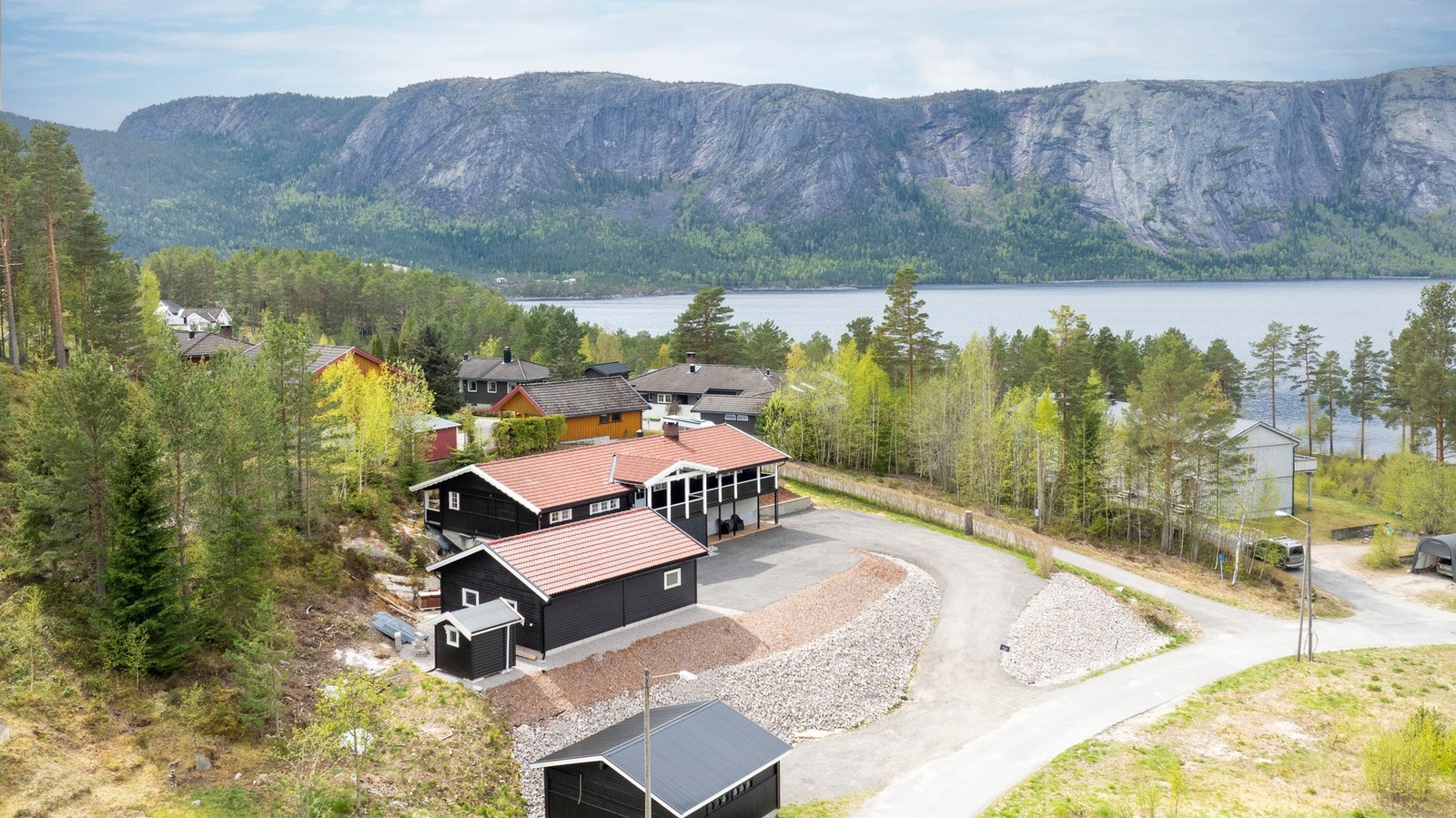 Vidstrakt utsikt mot vann og fjell, som gir området en lun og naturnær atmosfære året rundt. Galleribilde