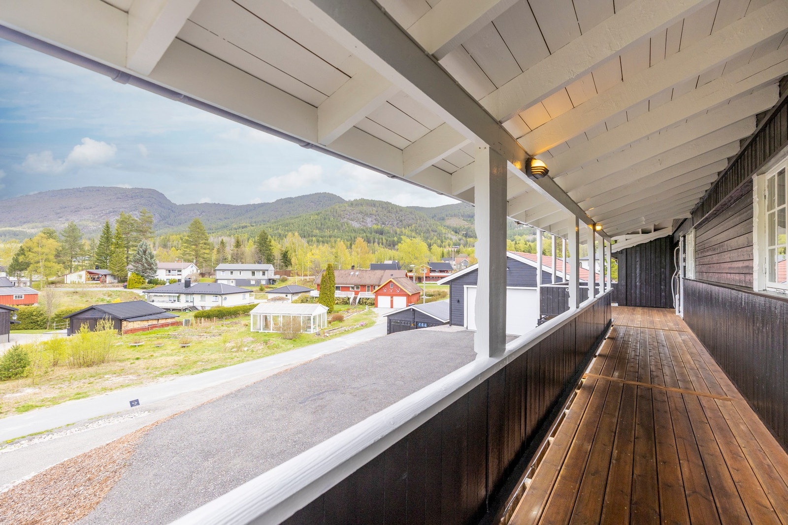 Romslig, overbygd veranda som strekker seg langs fasaden og gir gode sol- og oppholdsforhold. Galleribilde