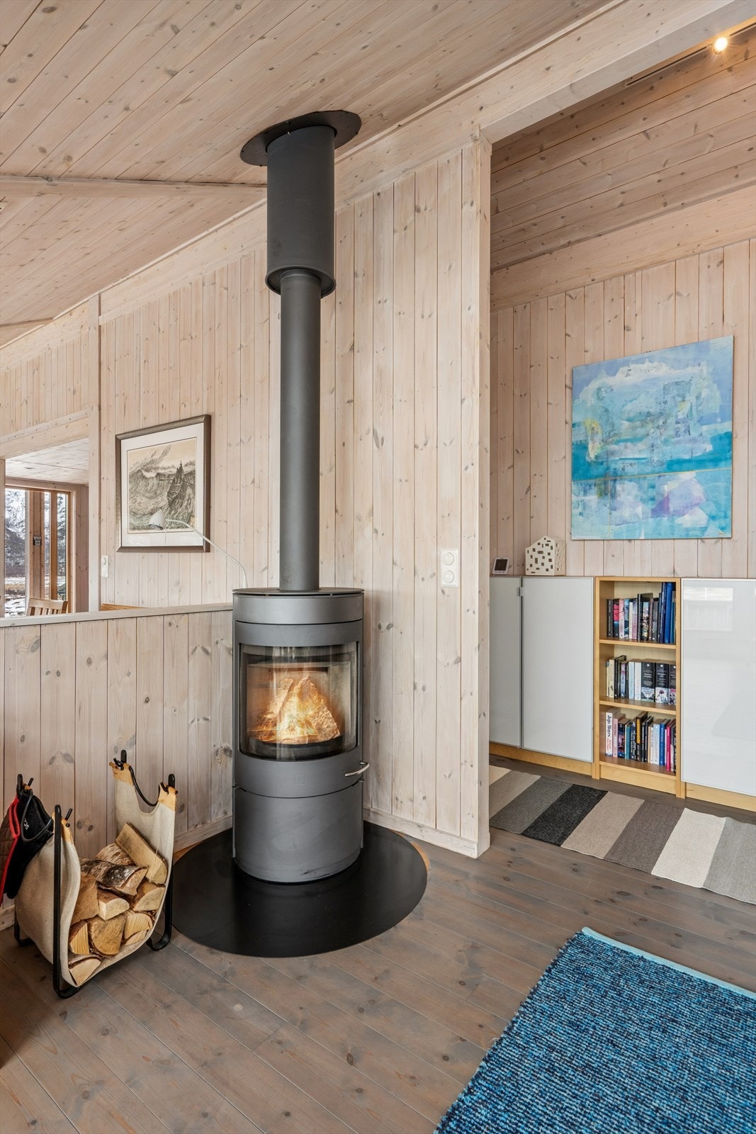 Ildstedet er sentralt plassert mellom stue og spisestue, og fungerer som et naturlig samlingspunkt. Galleribilde