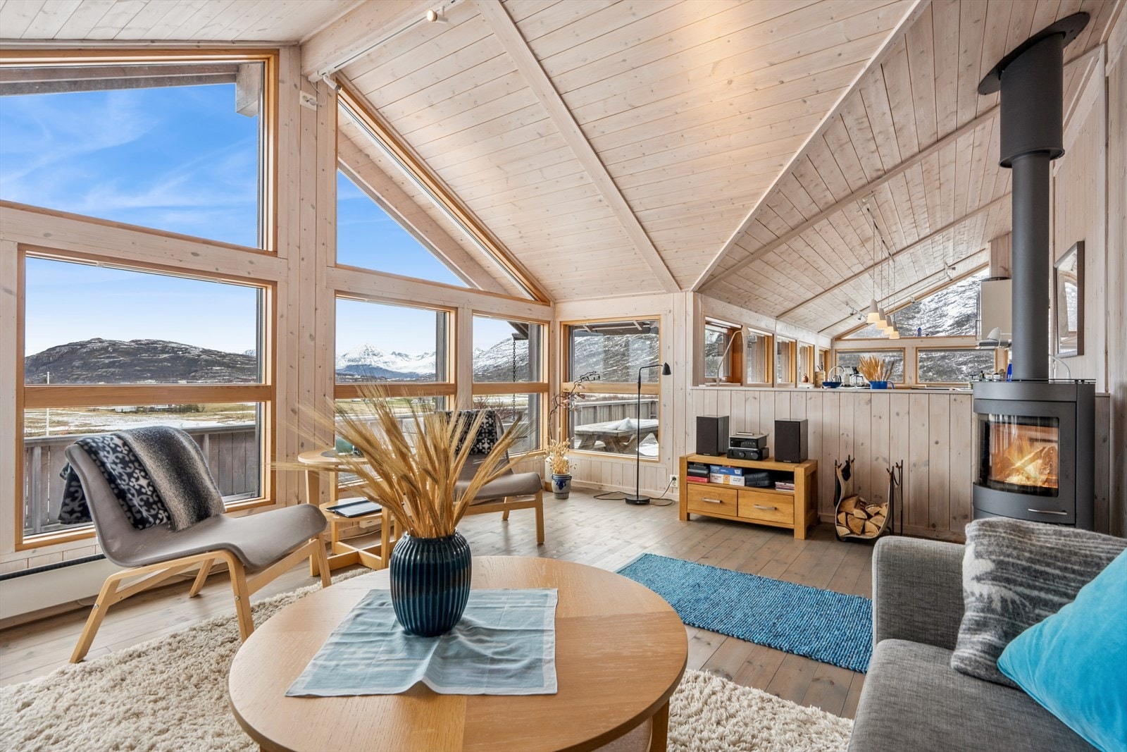 En massiv terrasse på 186 m² omkranser hytta og visker ut skillet mellom inne og ute. Her er det rikelig med plass for flere sittegrupper. Galleribilde
