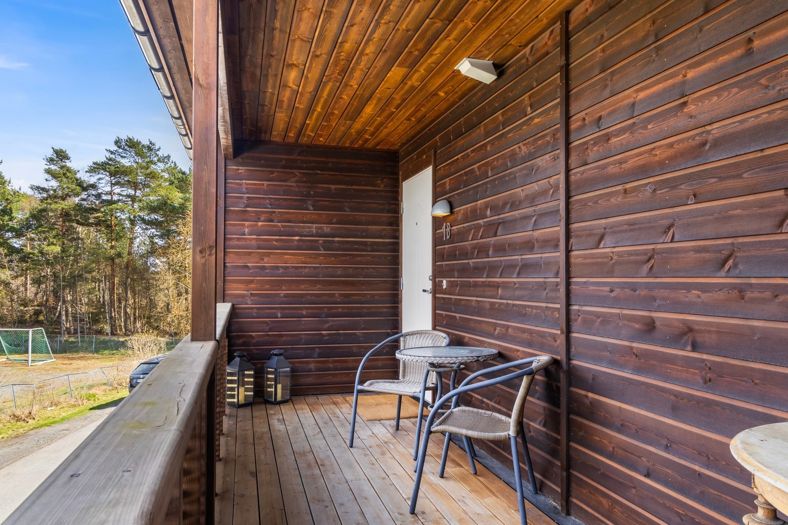 Overbygget inngangsparti med plass til en liten sittegruppe. Galleribilde