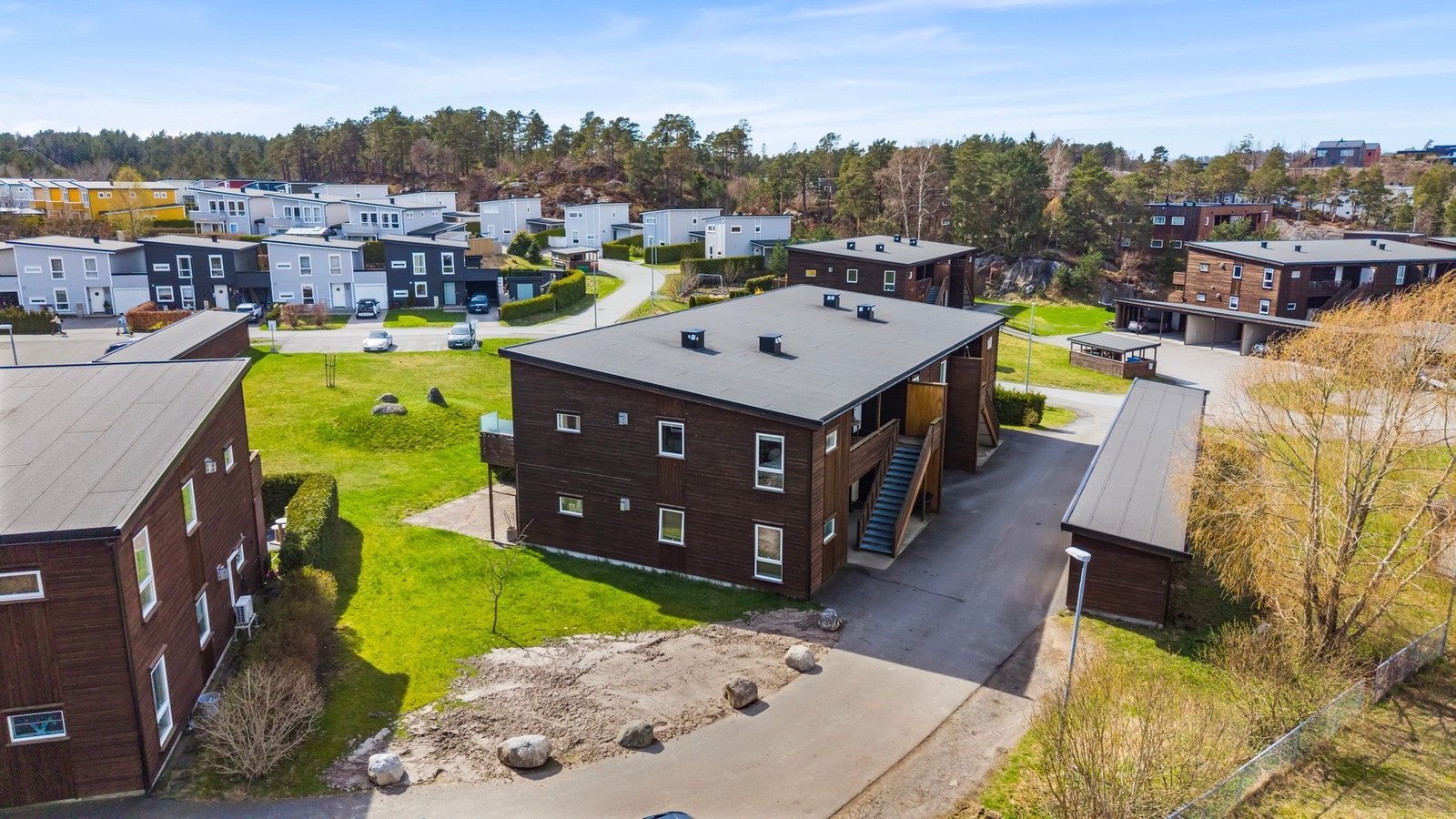 Bygget har trepanelte fasader og ligger i et etablert boligområde. Galleribilde