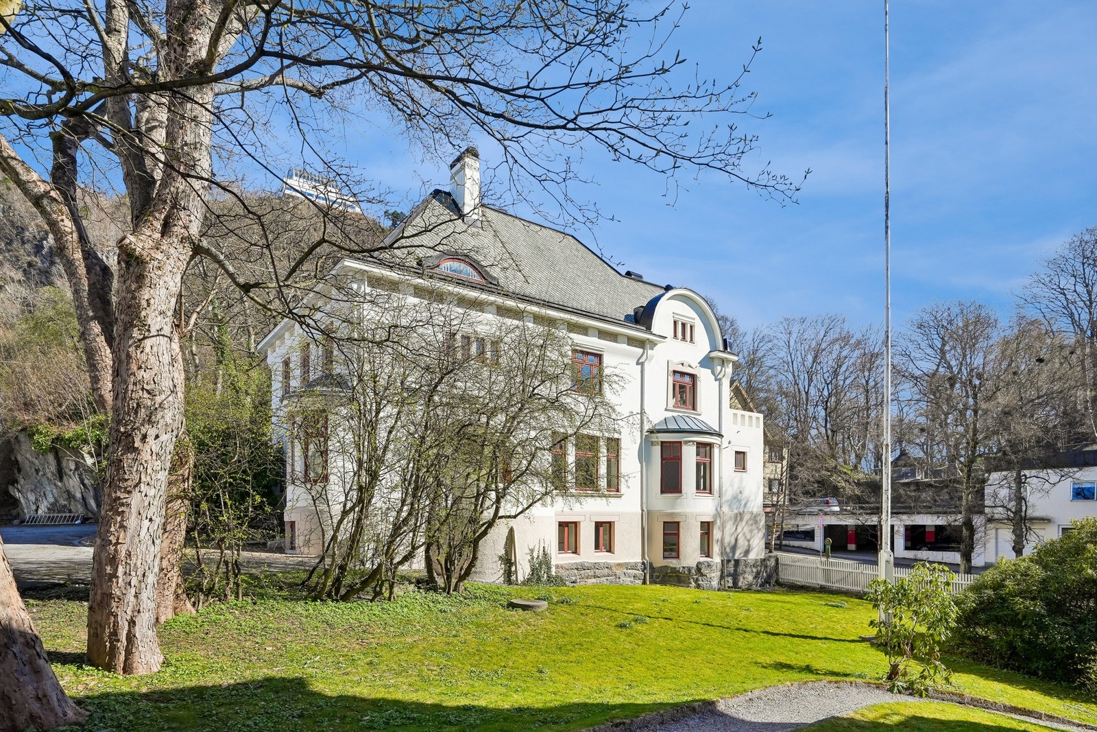 Rundt huset er tomten opparbeidet med gangstier, flaggstang, belegningsstein og store plenarealer. Galleribilde