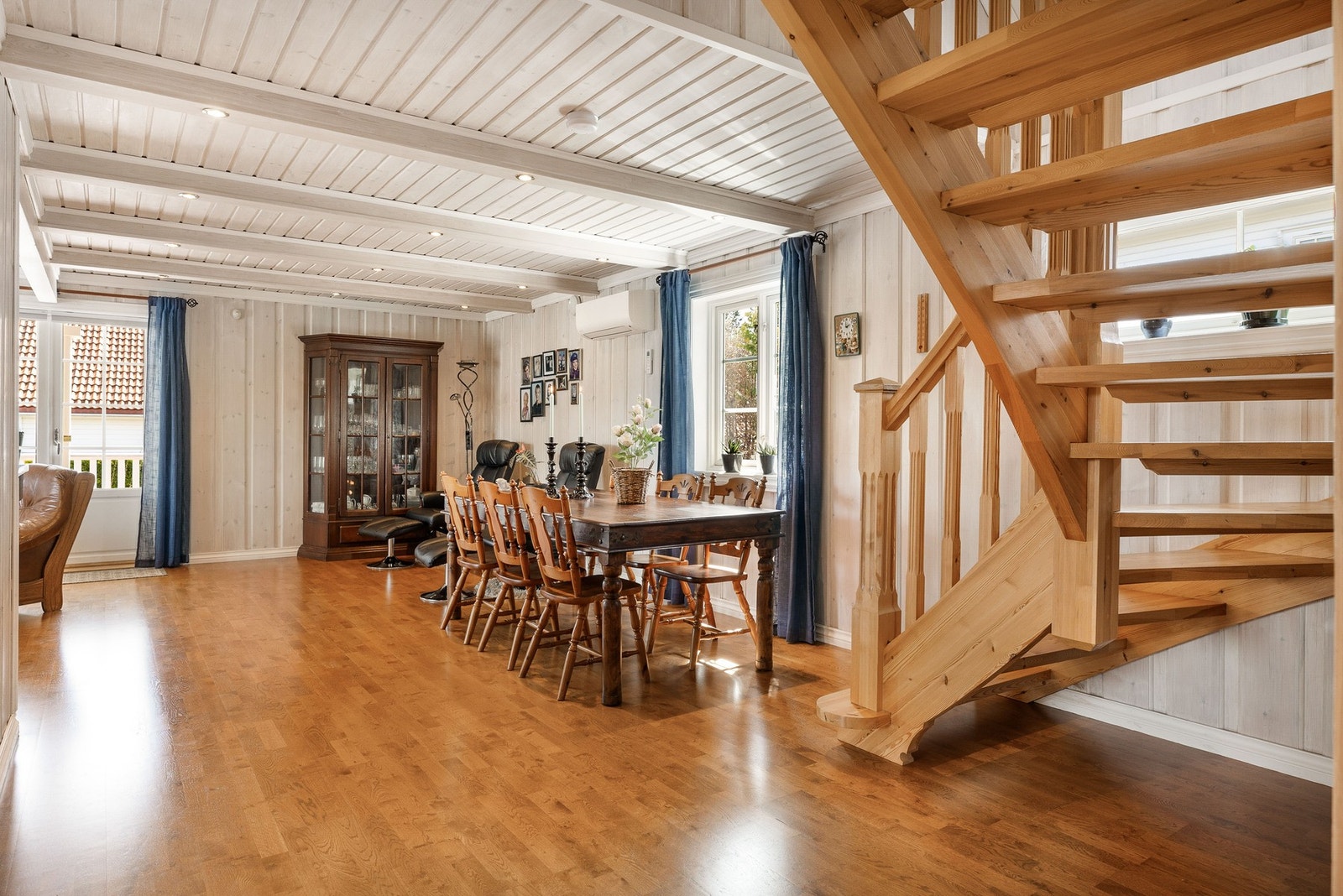Romslig stue med åpen trapp til loftsetasjen. Pent panel på vegger og i tak. Her er det enkelt å sette sitt personlige preg dersom man ønsker andre fargevalg. Galleribilde