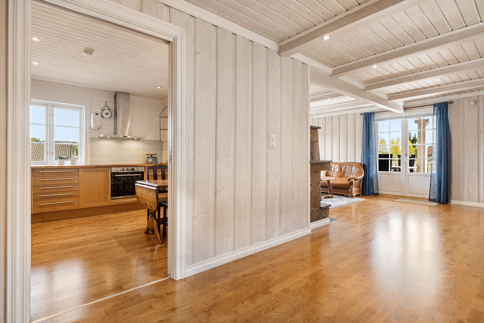 Kjøkkenet ligger praktisk til ved siden av stuen, med en romslig åpning mellom rommene. Galleribilde