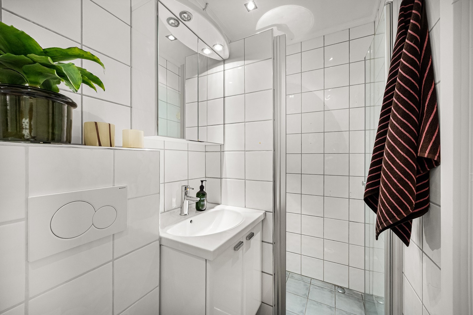 Badet inneholder dusjhjørne, veggmontert servantskap, toalett (sisterne byttet 2025) og vaskemaskin Galleribilde