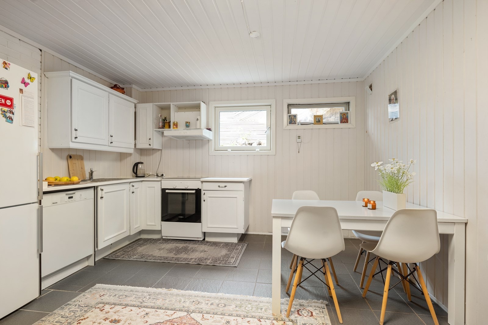 Kjøkkeninnredning med profilerte fronter og opplegg for oppvaskmaskin i den separate delen. Galleribilde