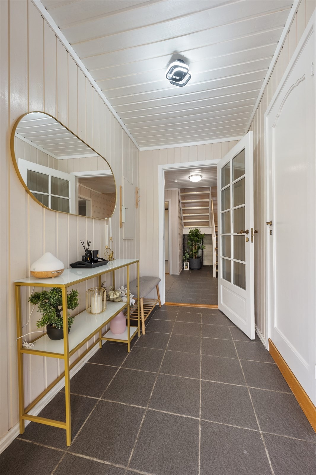 En dør med glassfelt slipper lyset videre inn fra entréen til gangen. Galleribilde