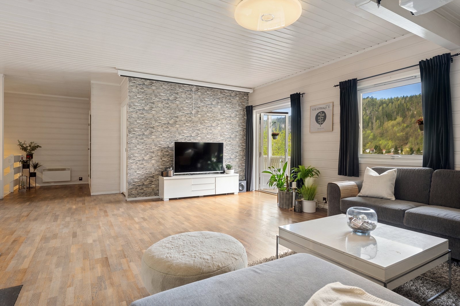 Rommet har god plass til flere sittegrupper og en åpen forbindelse mot spiseplassen. Galleribilde