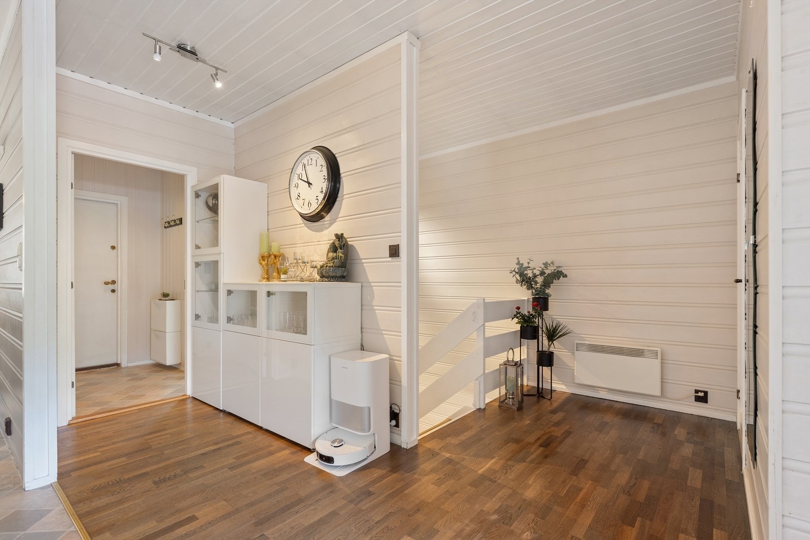 Ankomsten til første etasje, hvor gangen og stuen har gjennomgående parkettgulv. Galleribilde