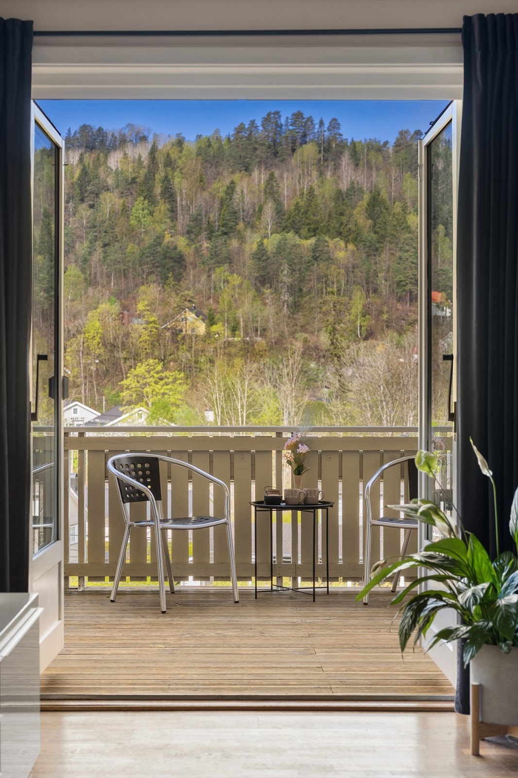 Fra stuen åpner verandadøren opp mot uteplassen og de grønne omgivelsene. Galleribilde