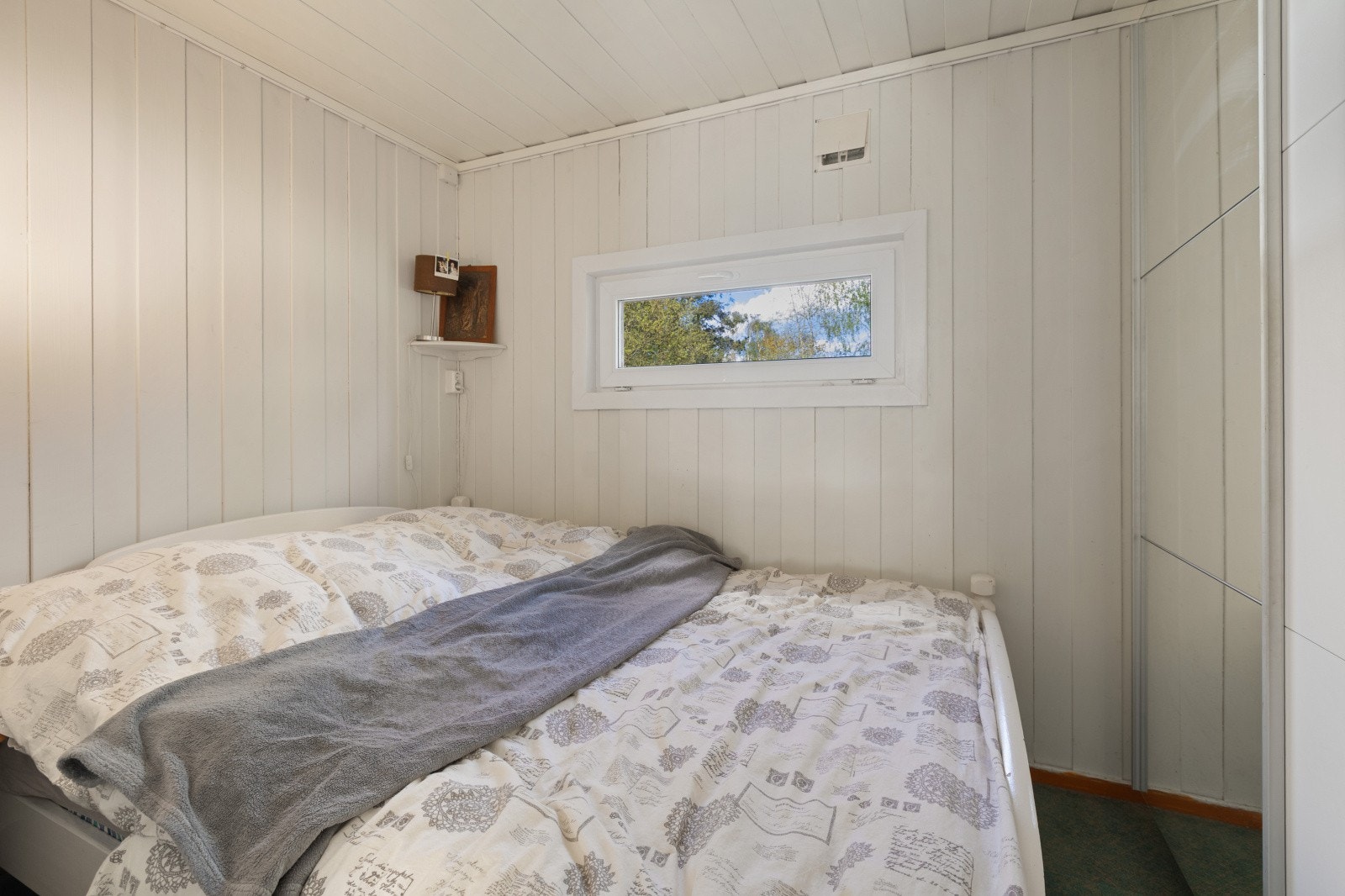 Soverom med lyse panelvegger og plass til dobbeltseng. Galleribilde