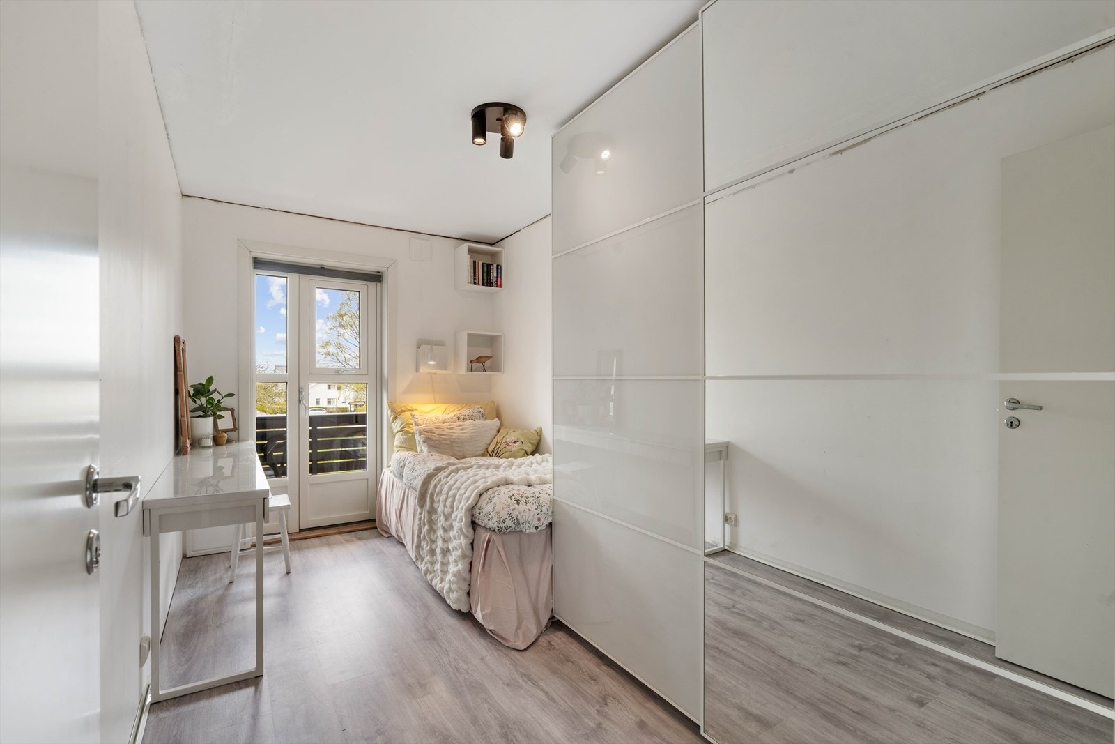 Soverom nummer to har god plass til seng, garderobeskap og et kontorhjørne, samt direkte utgang til en vestvendt balkong med flott utsikt Galleribilde