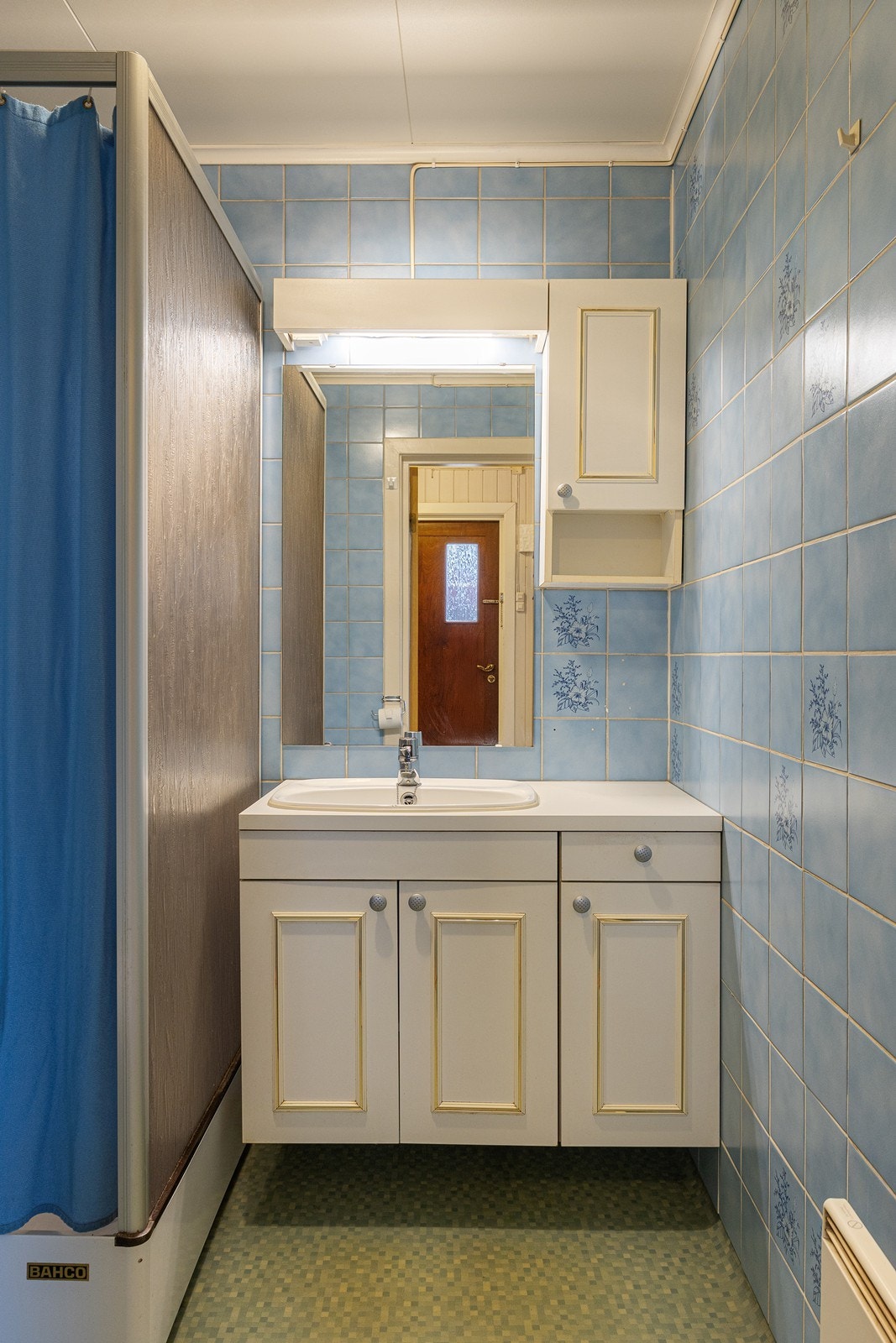 Badet i 1. etasje har fliser på veggene og vinylbelegg på gulvet. Galleribilde