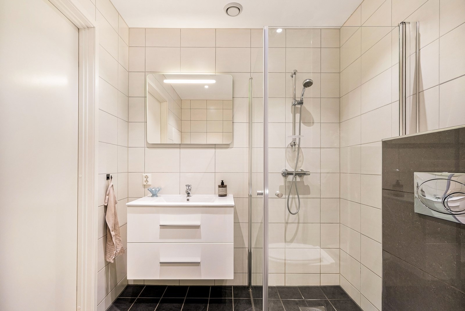 Badet ble renovert i 2017 og har flislagte overflater, elektriske varmekabler i gulvet og dusjhjørne med innfellbare dører. Galleribilde