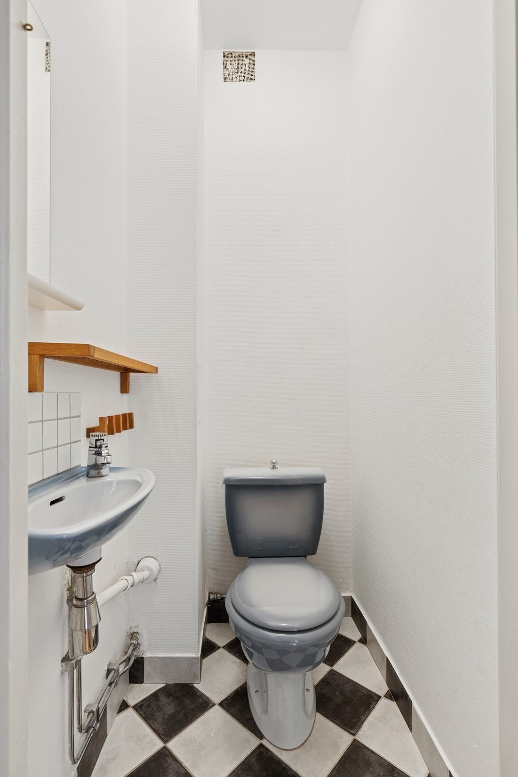 Leiligheten har et separat toalettrom med med flislagt gulv og vegger med malt glassfiberstrie. Rommet er innredet med farget servant og toalett. Galleribilde