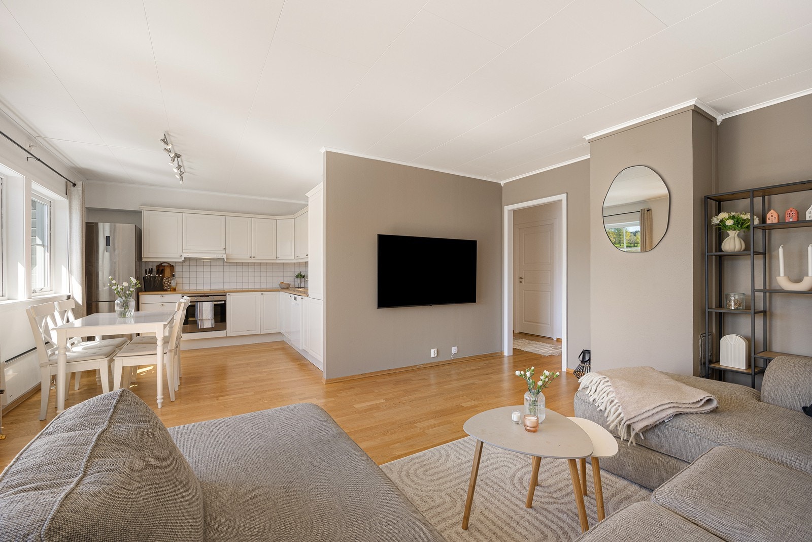 Parkett på gulvet kombineres med malte vegger i en dus gråtone i stuedelen. Galleribilde
