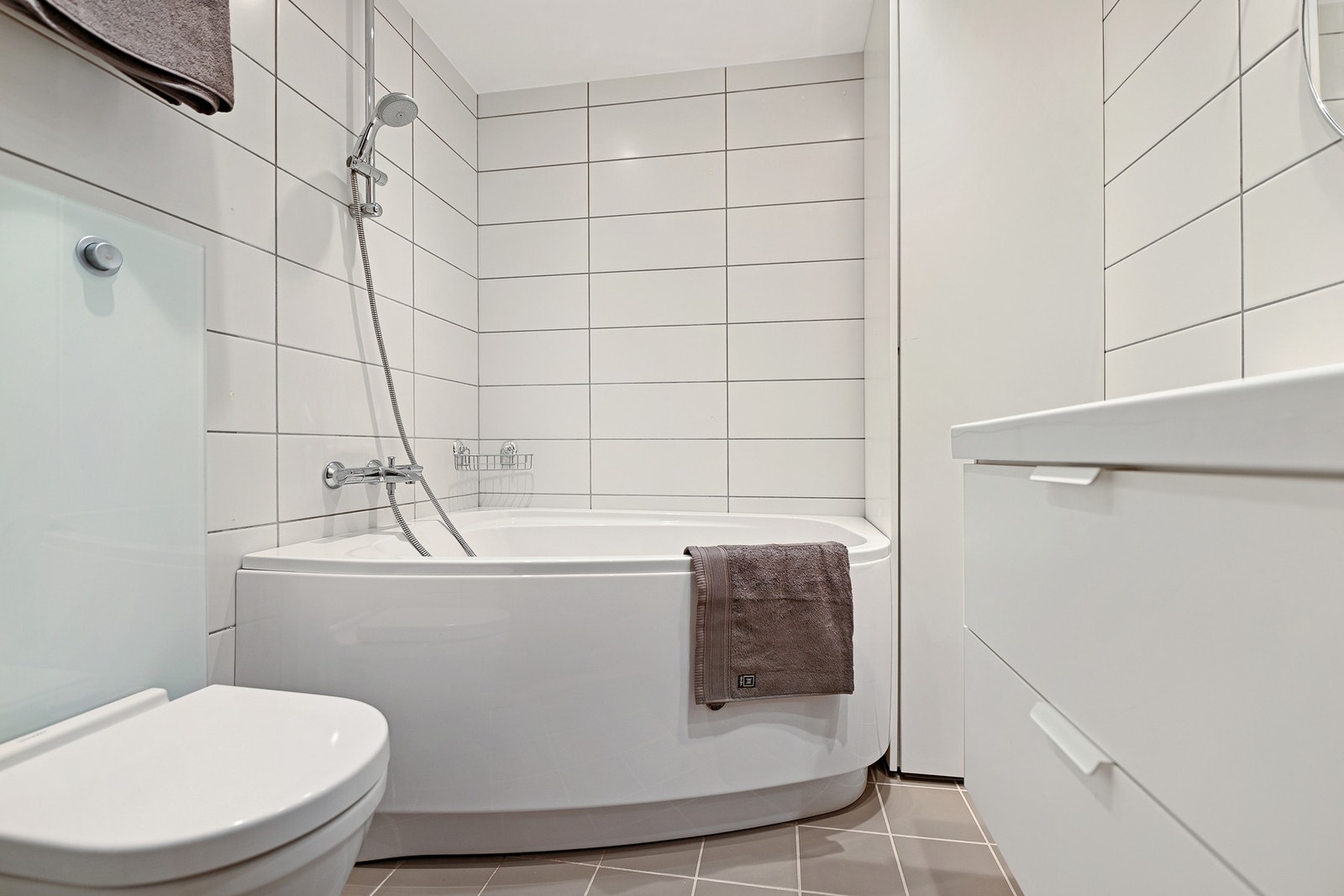 Badet i 2. etasje er innredet servant, veggfestet toalett og badekar. Galleribilde
