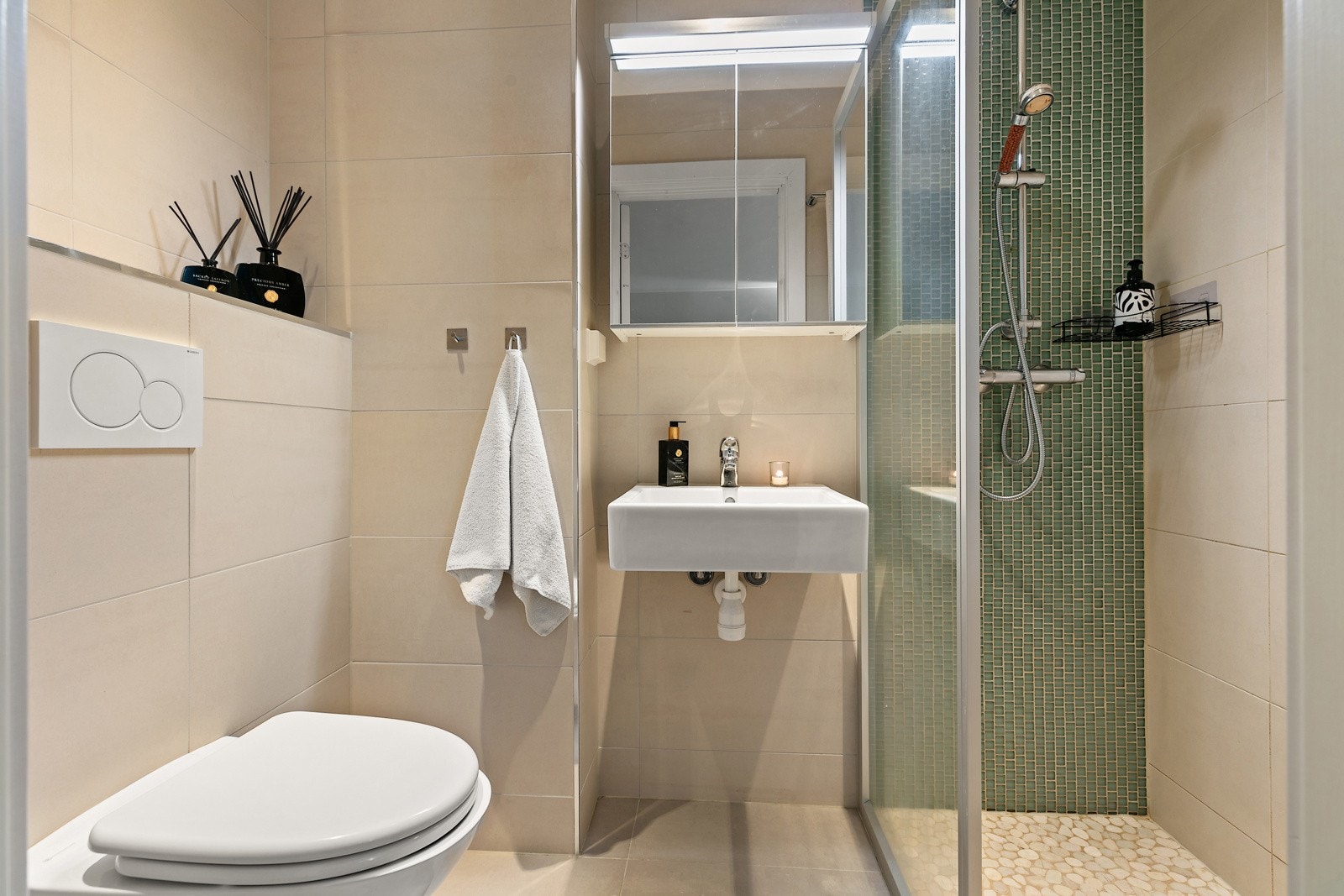 Dusjsonen på hovedbadet - naturstein på gulv og grønn glass-mosaikk på vegg. Galleribilde