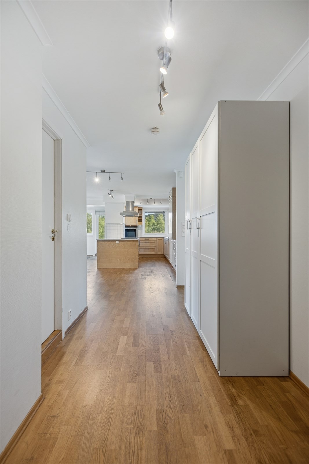 Entréen gir en naturlig adkomst videre til leilighetens oppholdsrom og bidrar til en åpen og innbydende romfølelse. Galleribilde