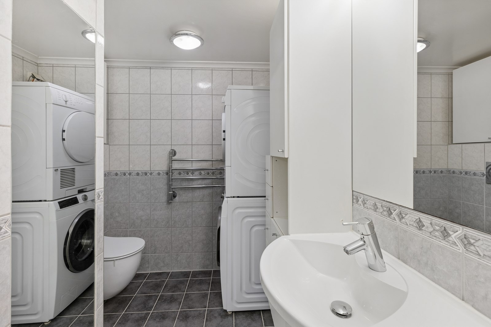 Hovedbadet er romslig utformet og innredet med dobbel servant med skapløsning, vegghengt toalett med skjult sisterne, innmurt boblebadekar med dusjløsning og glassvegger, opplegg for vaskemaskin samt håndkletørkere. Galleribilde