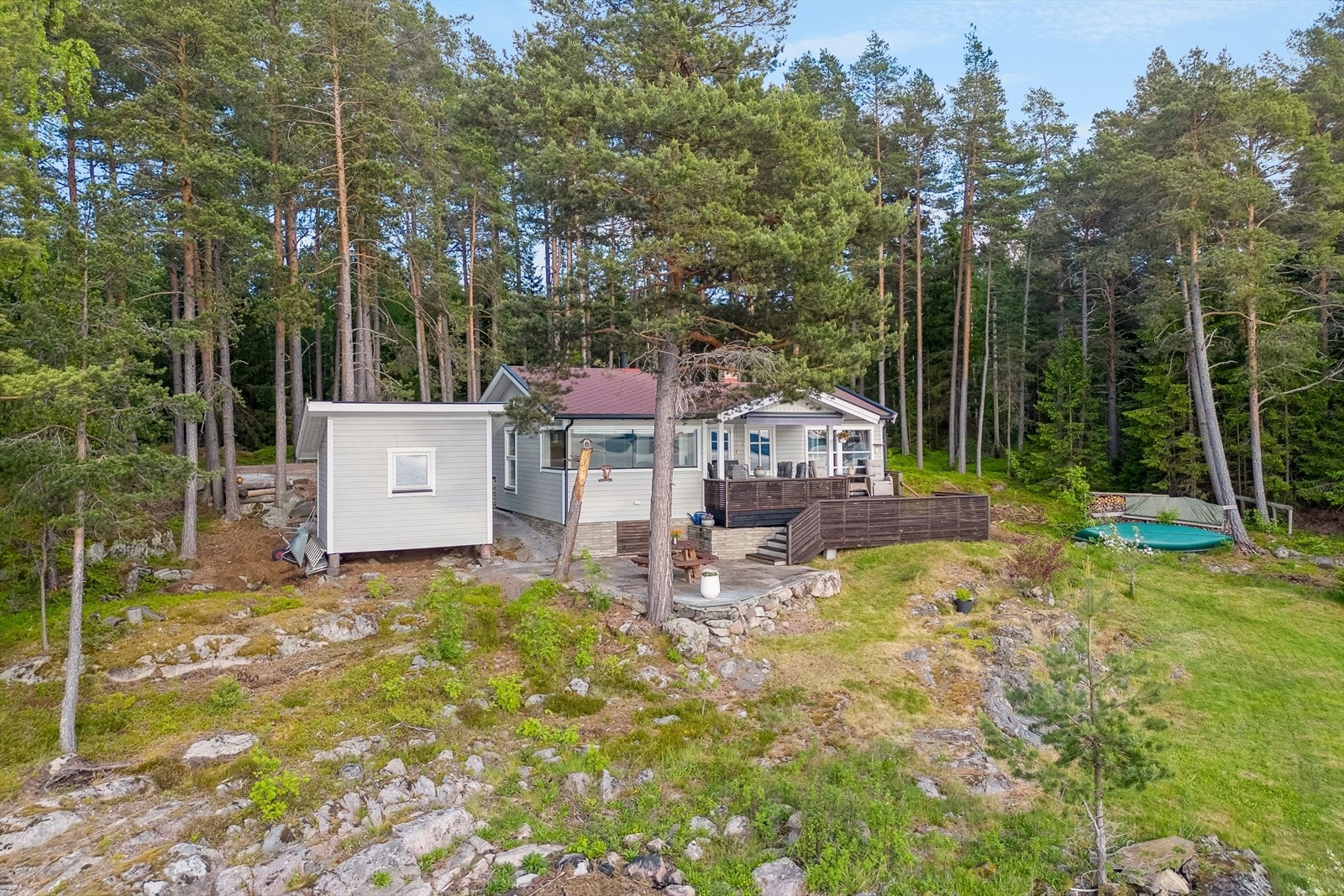 Hytta omkranses av furutrær og har fine uteplasser i flere soner og nivåer. Galleribilde