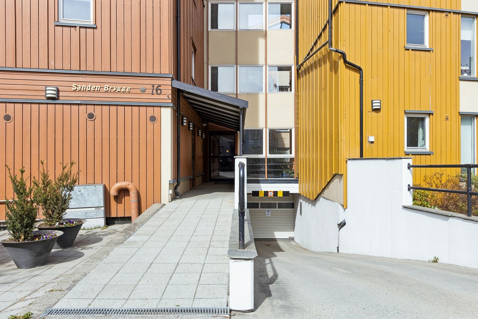 Fasaden som vender ut mot Sandgata. Nedkjøring til parkeringskjelleren er mellom bryggene. Galleribilde