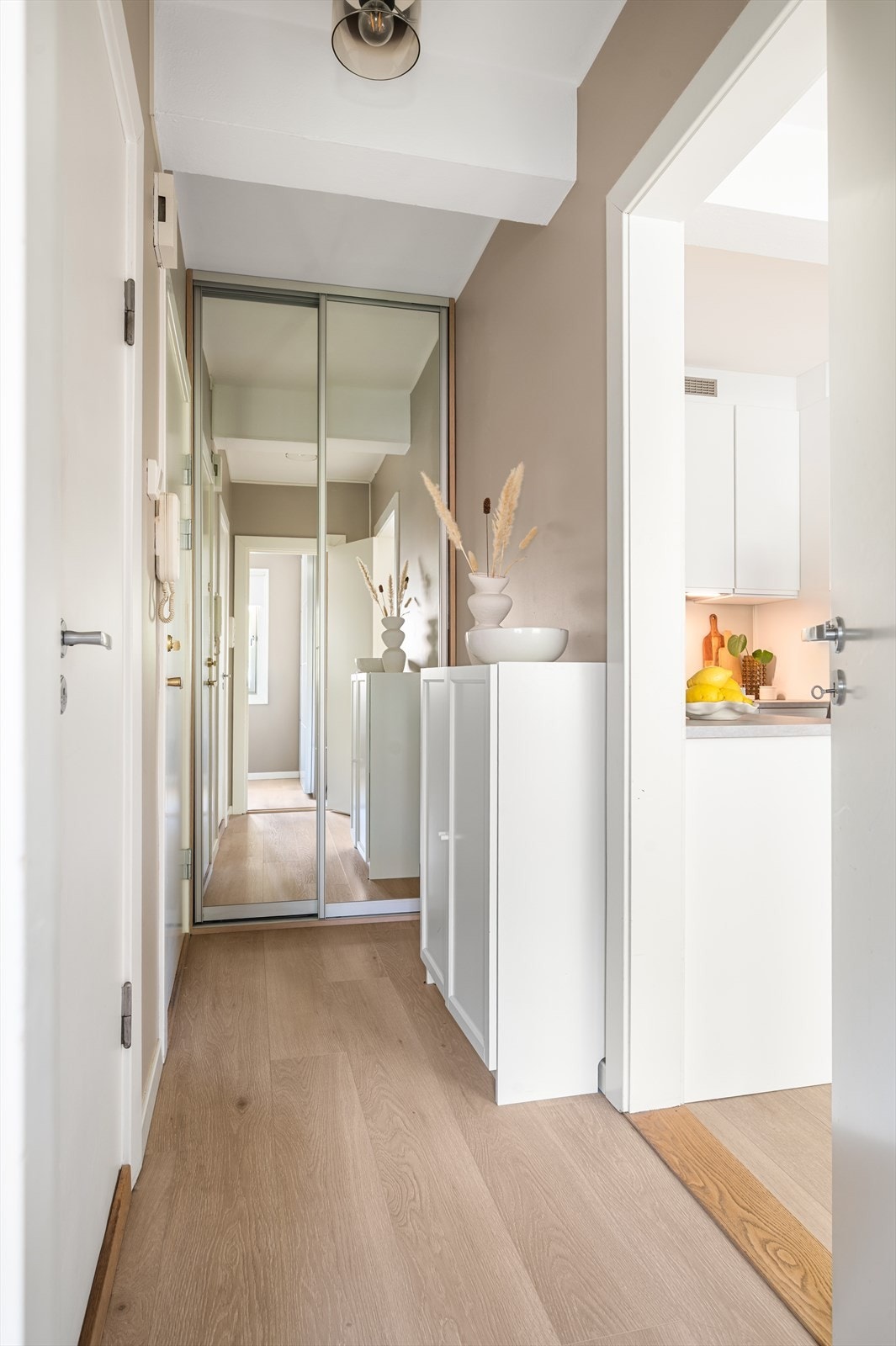 Plassbygd skyvedørsgarderobe med speilfronter gir rikelig med oppbevaring i entreen. Galleribilde