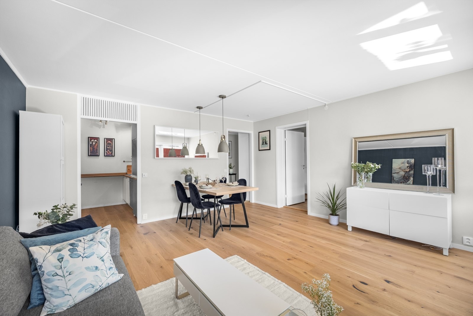 Boligen har en lys og luftig stue, med én vegg malt i blått som en fin kontrast. Galleribilde