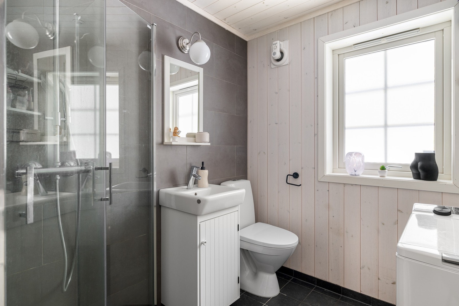 Badet har flislagt gulv med gulvvarme, flis og panel på vegger og i innvendig tak, innfelte spotlights i tak. Galleribilde